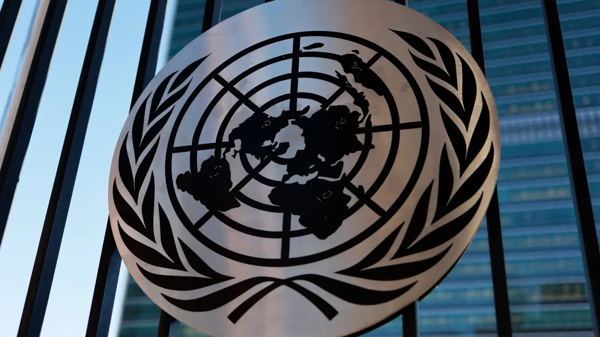 The United Nations logo is seen on a fence.