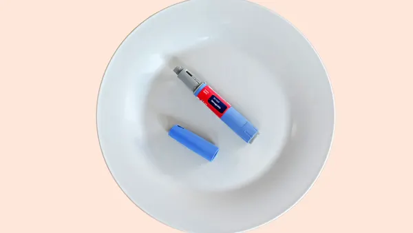 An injection pen containing the drug semaglutide lies on a white plate.