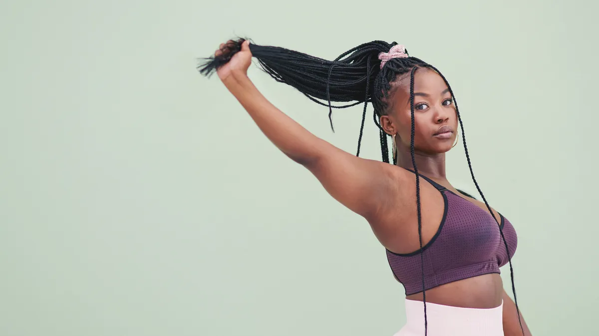 A Black person in fitness attire poses for the camera