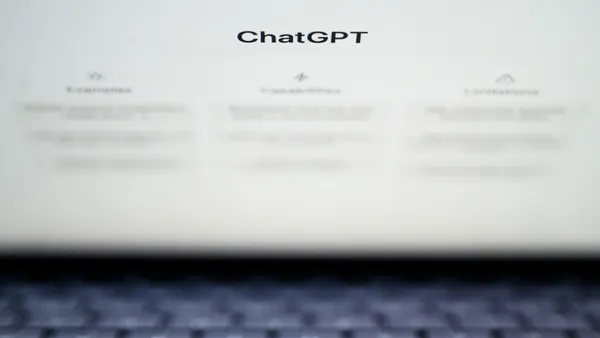 A laptop screen shows the word "ChatGPT" and three columns of blurred-out text
