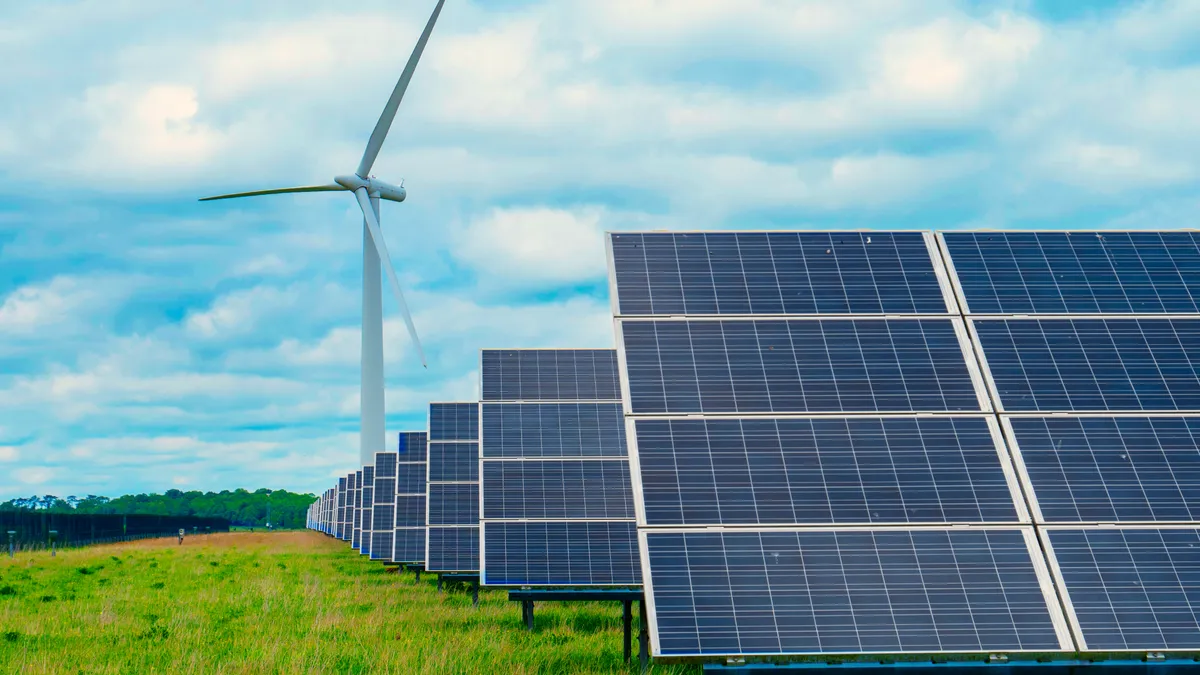 Renewable energy solar panels and wind turbine in the background