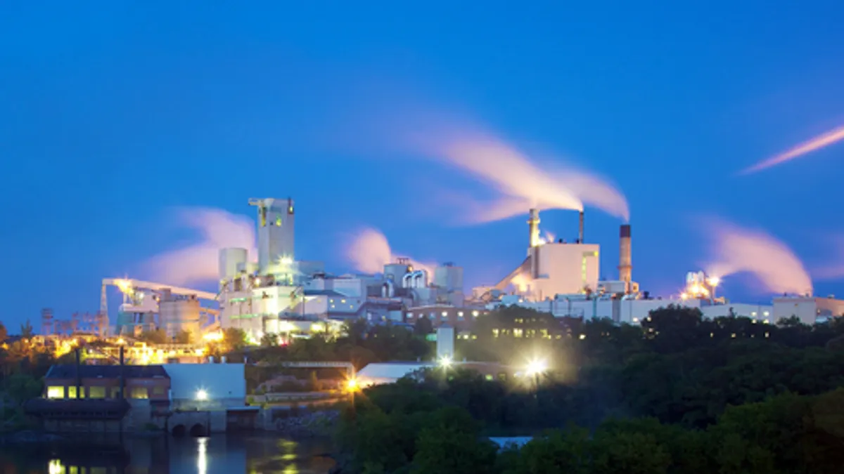 Exterior view of a paper and pulp mill at twilight.