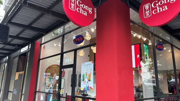 A Gong cha store with the open sign and drink menu displayed on the storefront's windows.