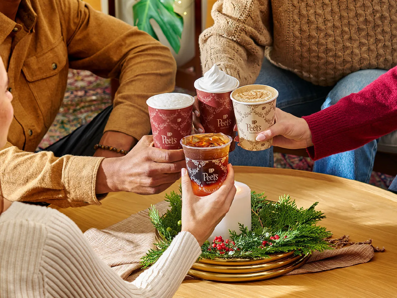 Individuals holding Peet's Coffee seasonal drinks