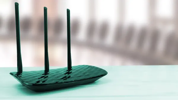 A wireless router sits on a flat surface