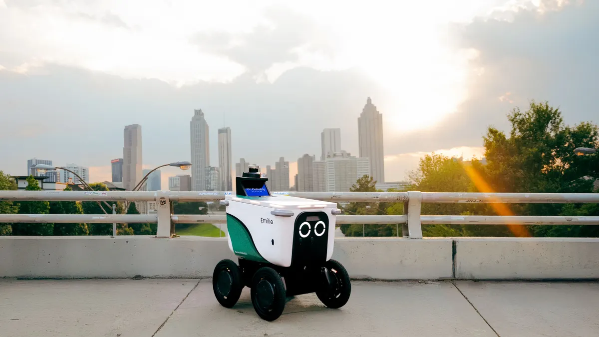 A Serve Robotics Robot in front of Atlanta's skyline.