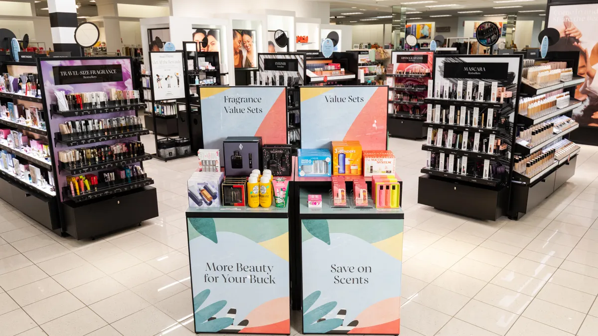 In-store displays of beauty products, with signs in the front that say "more beauty for your buck" and "save on scents."