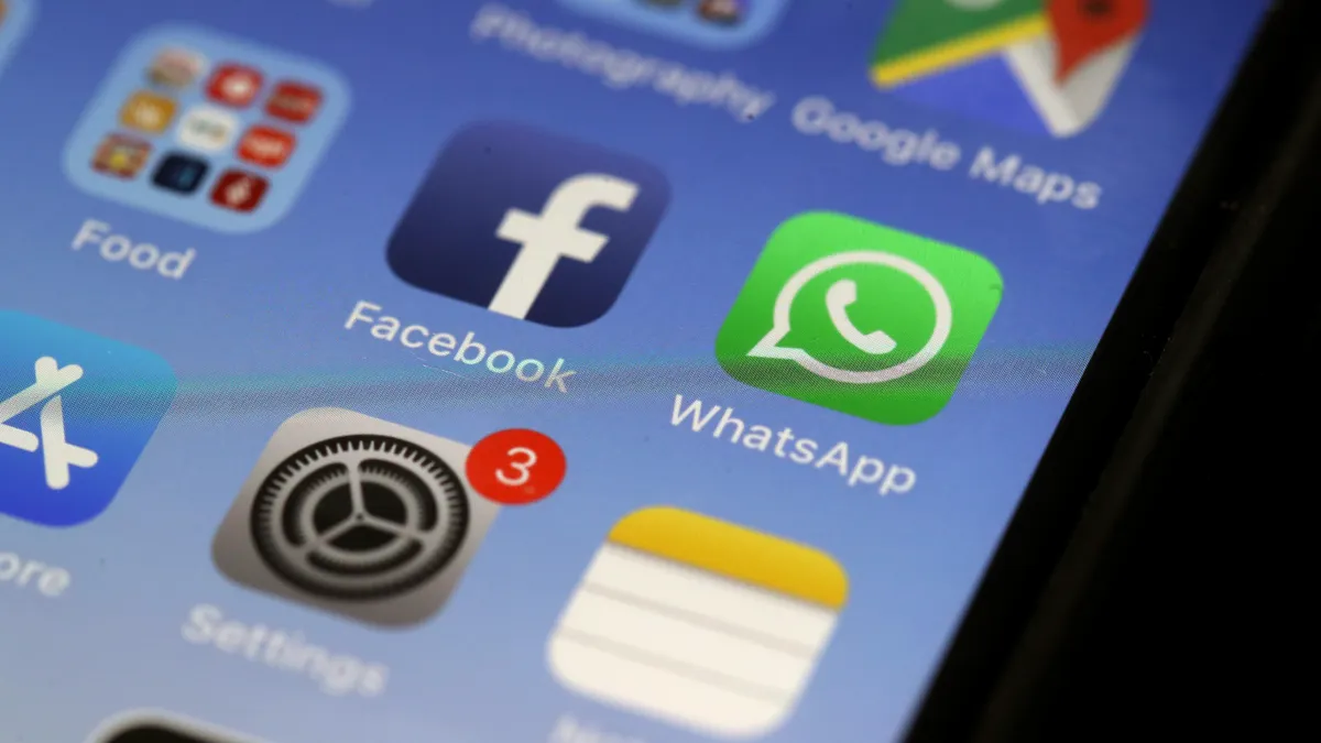 Icons of Facebook, WhatsApp and Settings appear on a lit phone screen.