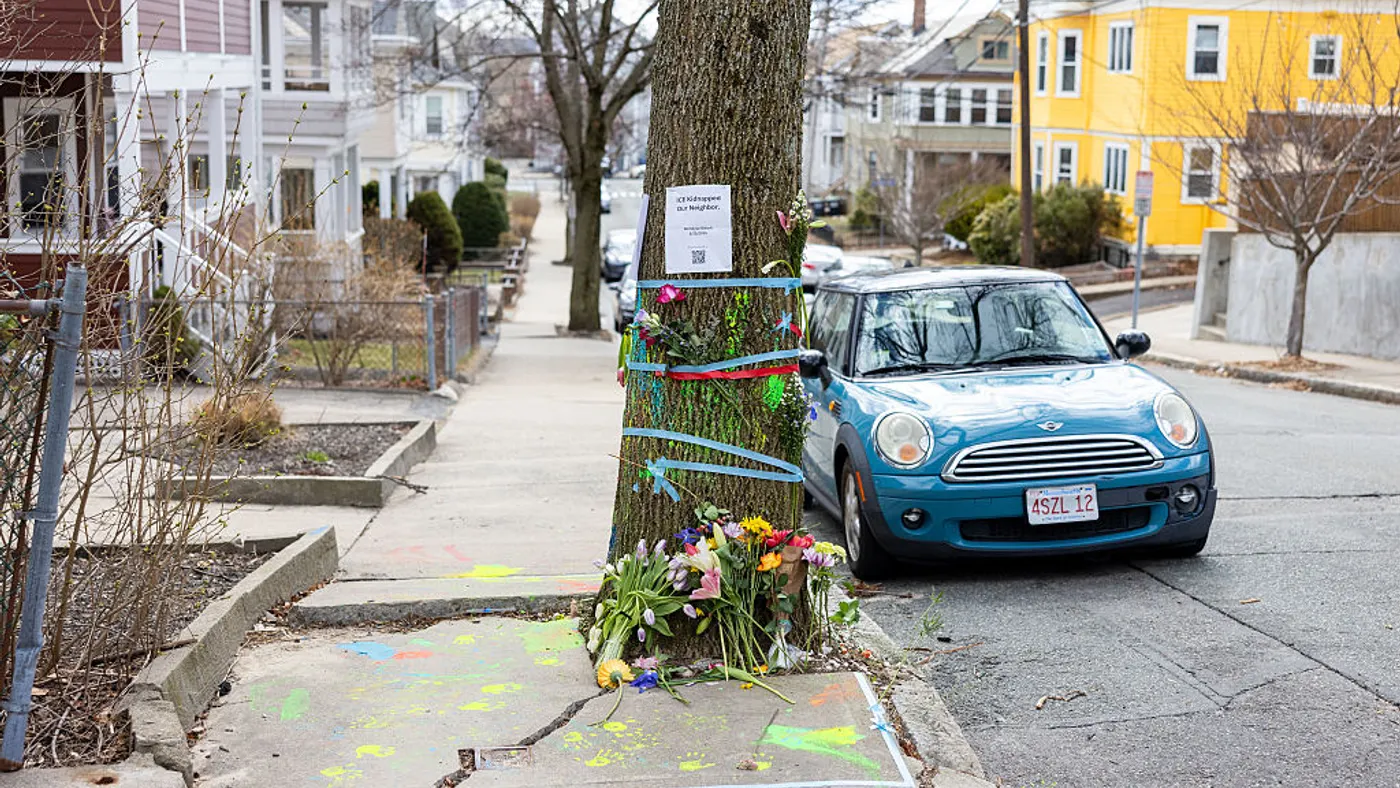Signage and flowers decorate the tree where ICE officials detained Rumeysa Ozturk.