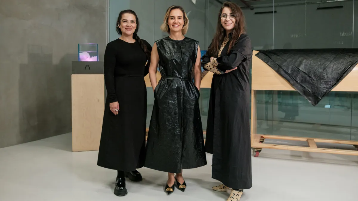 Three people stand for a professional photo.