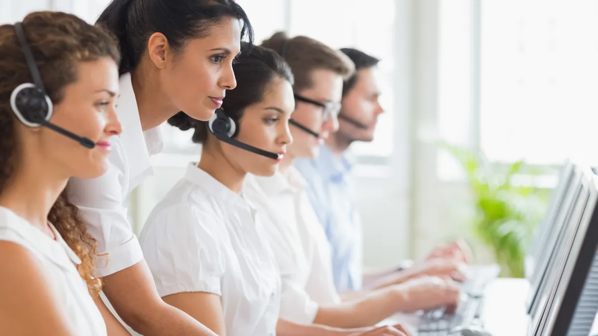 A call center manager assists her team.