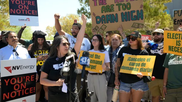 protesters hold signs including "the rates are too damn high"