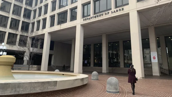 A person walks toward the door of the U.S. Department of Labor building.