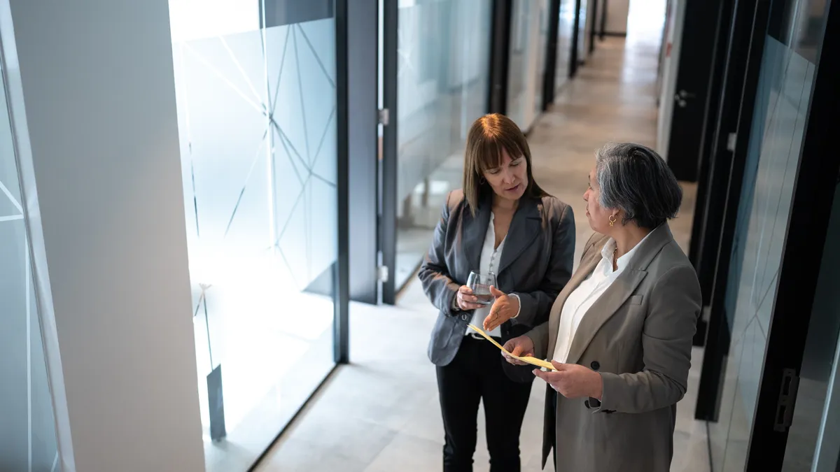 Businesspeople walking and talking in the office's corridor