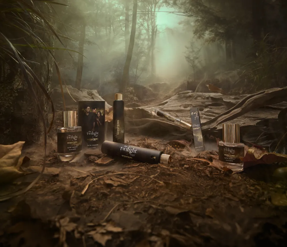 Bottles of The Twilight Saga: New Moon Eau de Parfum by Scentbird scattered on the ground in the woods