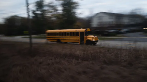 A school bus drives down a country roadside