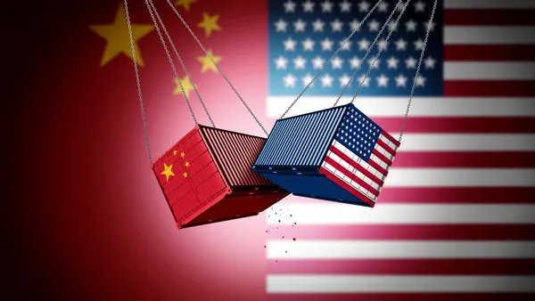 Two cargo freights with the U.S. and China flags on them bumping into each other.