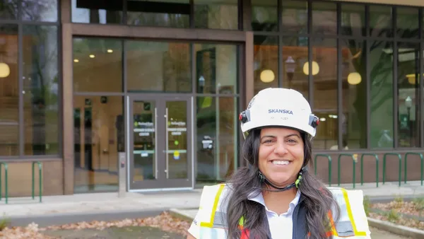 Image of woman construction worker infront of building