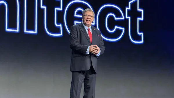 Gene Alvarez speaking on stage in business attire