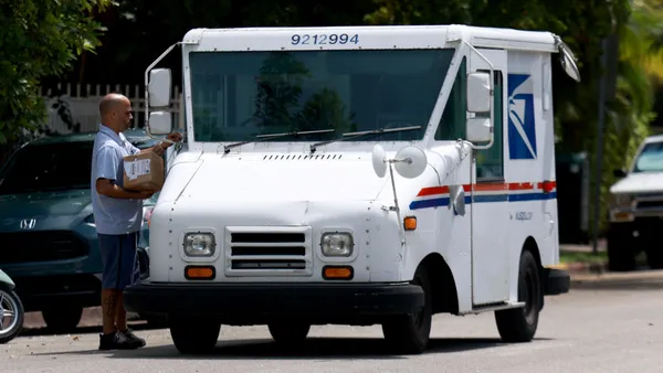 A United States Postal Service courier delivers mail on Sept. 12, 2024 in Miami Beach, Florida.