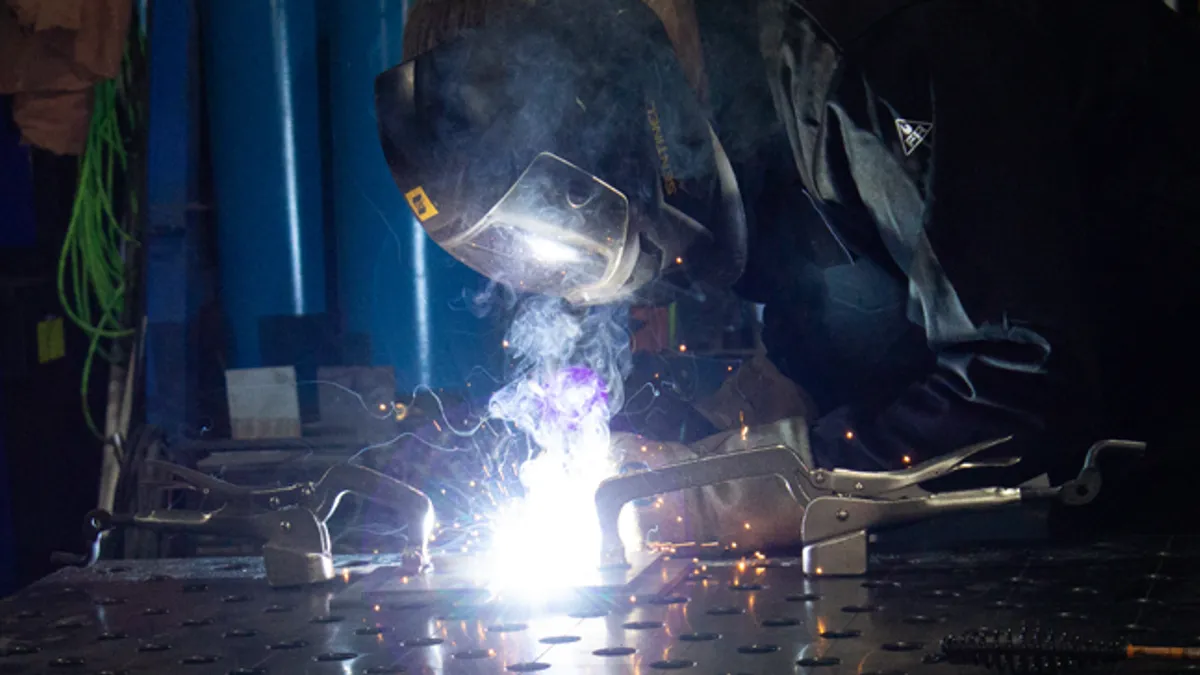 Man with helmet on welding metal