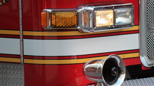 A close-up view of the front end of a red fire truck.