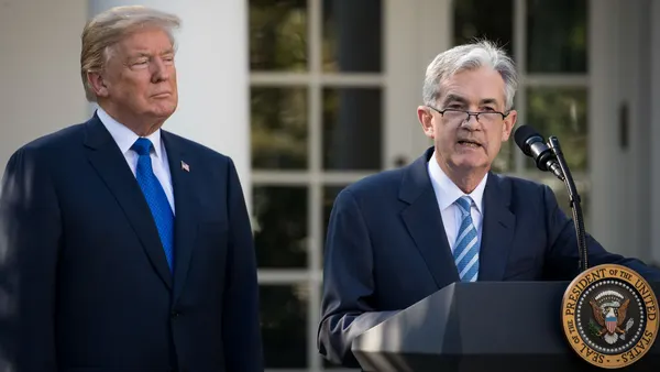 U.S. President Donald Trump looks on as Chairman of the Federal Reserve Jerome Powell gives a speech.