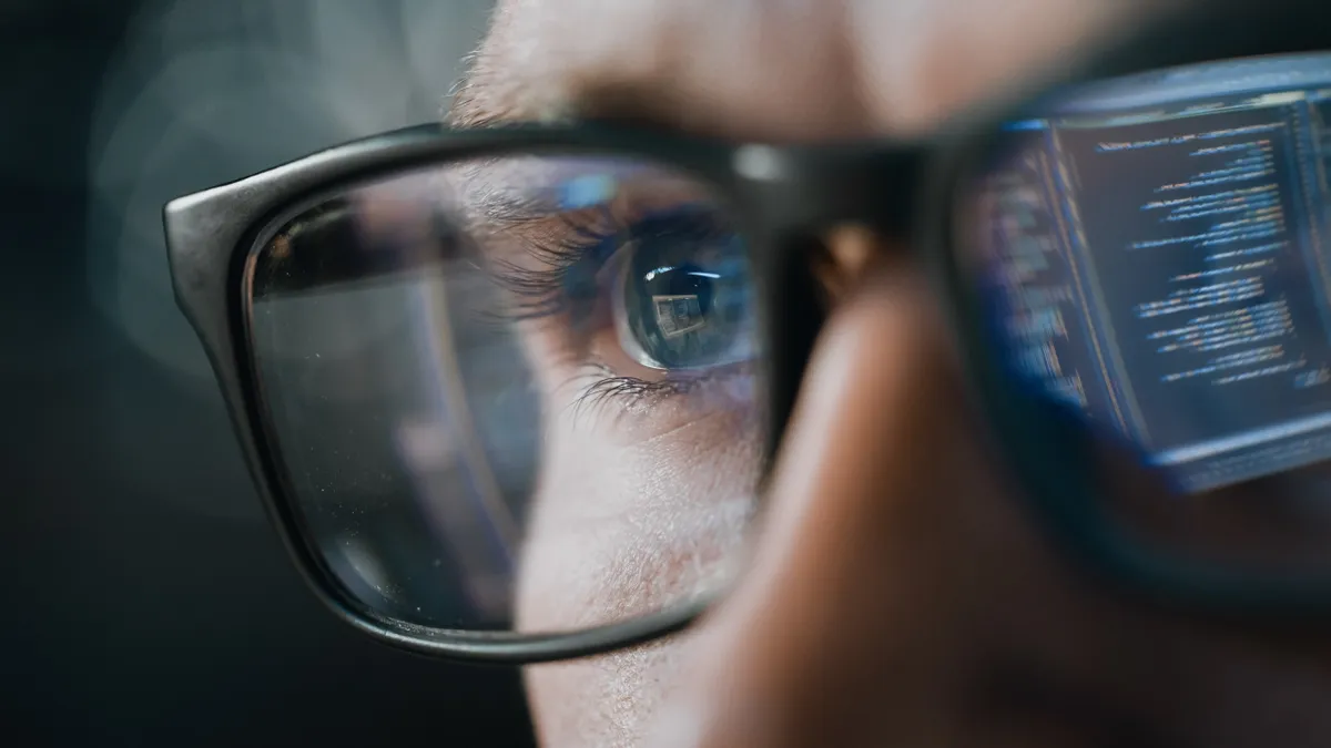 Close-up Portrait of Software Engineer Working on Computer, Line of Code Reflecting in Glasses.