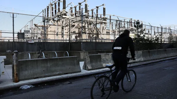 A person riding a bike past a power plant