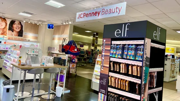 A space within a department store with beauty product displays, with an overhead sign reading "JC Penney Beauty."