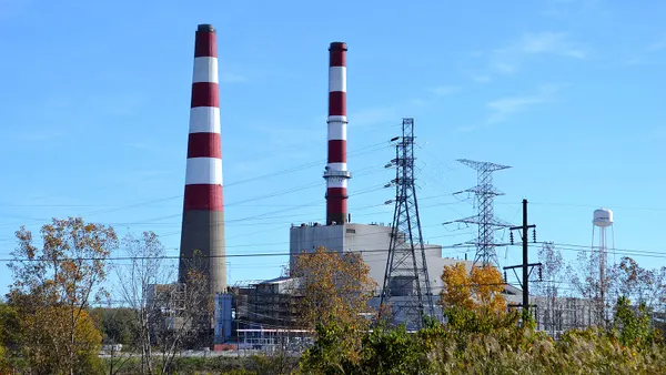 A power plant with two red and white striped smokestacks.