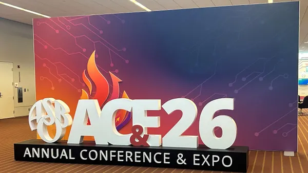 A large sign in a conference hall that says "ASBO AC&E annual conference & expo."