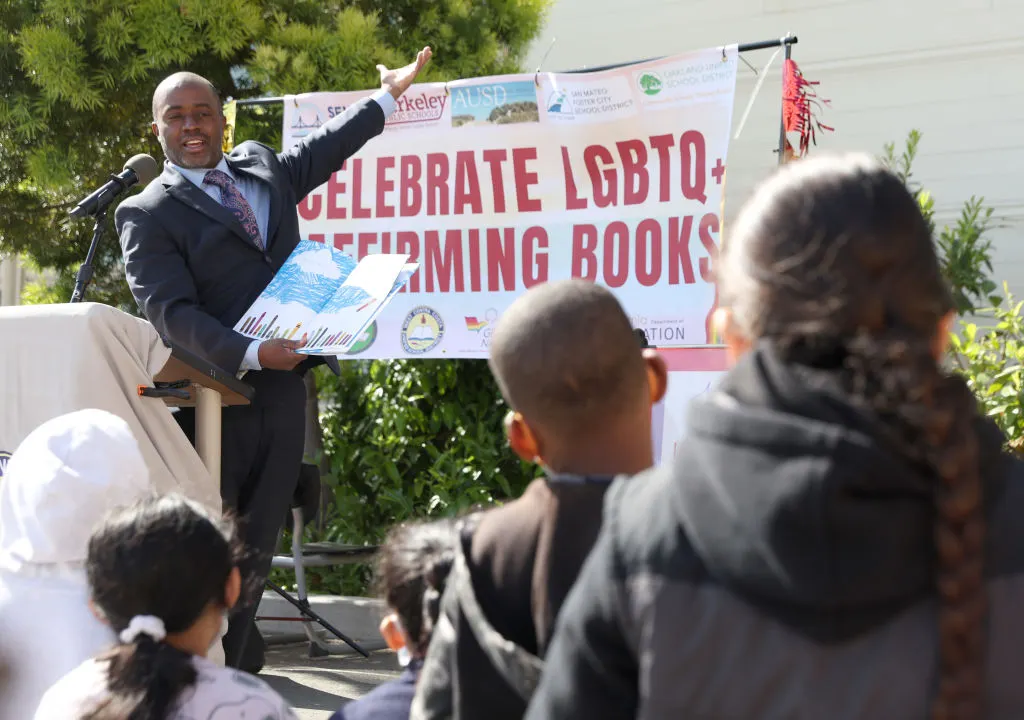 Tony Thurmond points to a poster reading &quot;Celebrate LGTBQ+ Affirming Books&quot;