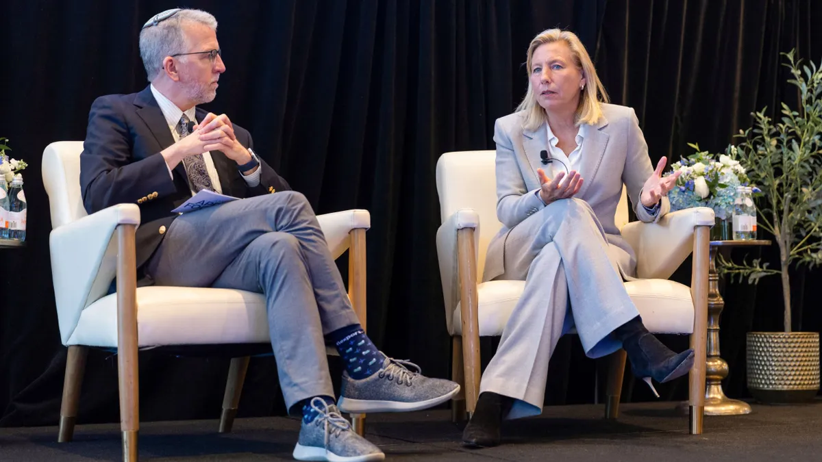 Stephen Lamar and Joanne Crevoiserat sit on a stage in conversation.