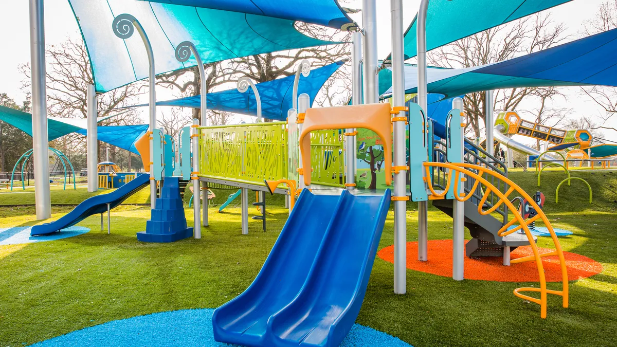 Modern playgound with slides, bridge, climbing stairs, and canopy