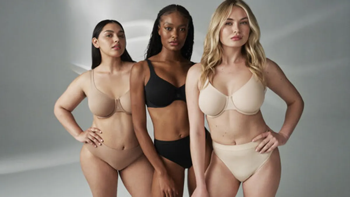 Three models wearing neutral toned intimates products
