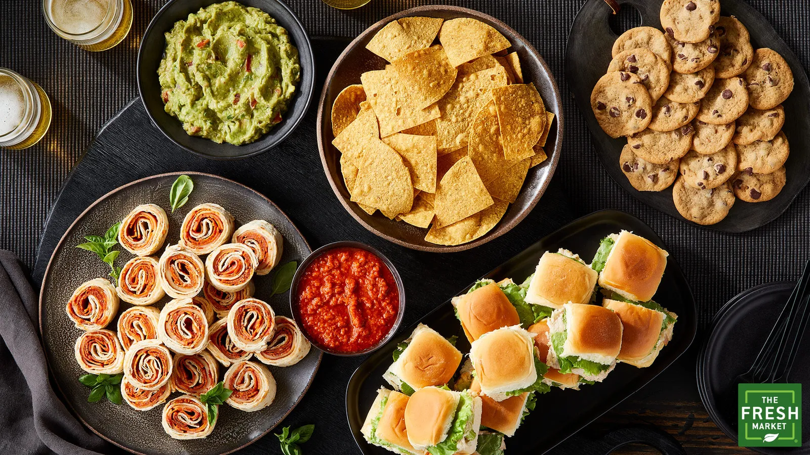 Food display of chips, sandwiches, wraps, dips and cookies