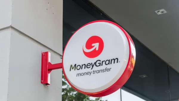 MoneyGram logo displayed on a building facade in Tirana, Albania, on June 4, 2022. The logo features a red circular icon with a white arrow, symbolizing global money transfers.