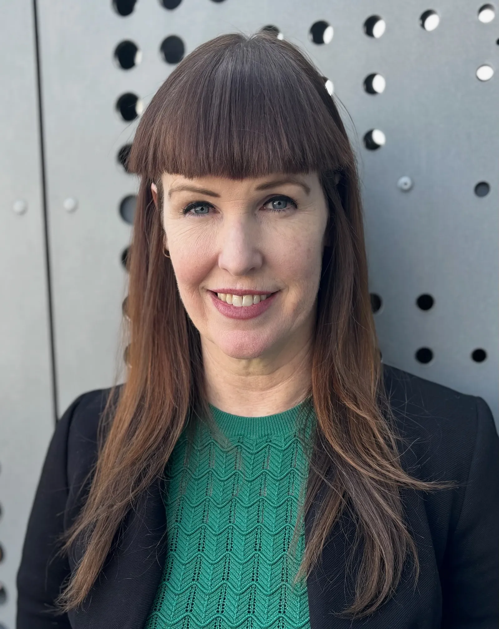 A headshot of a woman with bangs