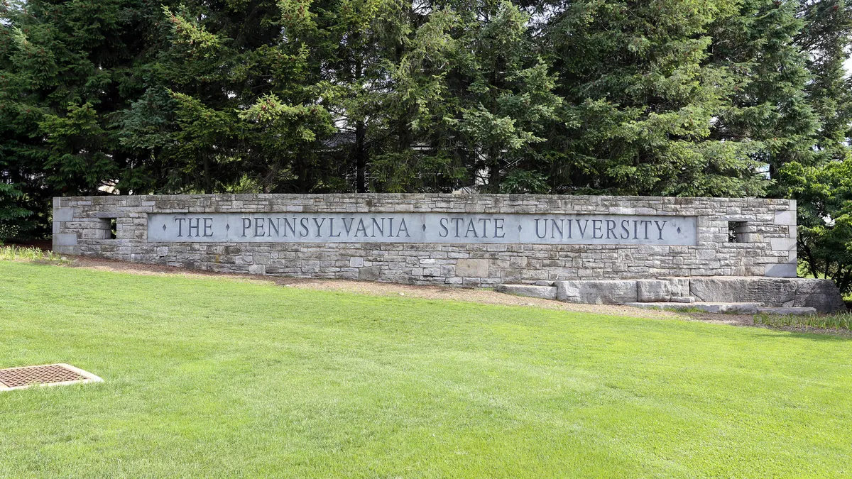 A sign reading "The Pennsylvania State University" at the entrance of the institution's main campus.