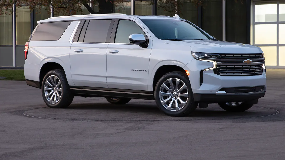 A white 2021 Chevy Suburban SUV with chrome wheels SUV parked outdoors.