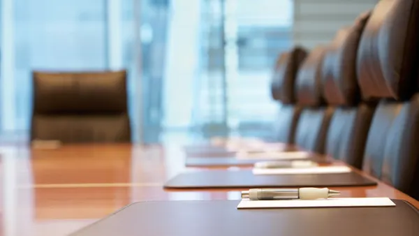 a boardroom table surrounded by office chairs