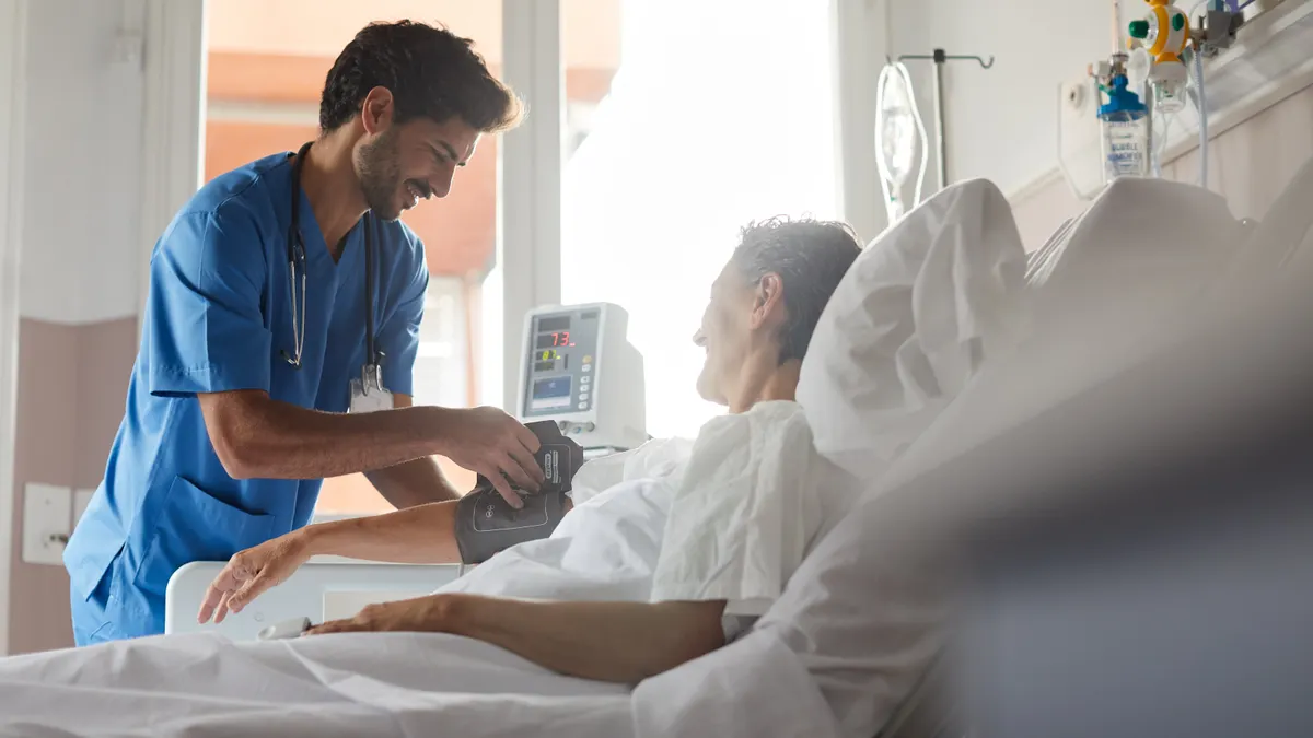 One male nurse is taking the pulse of a female patient.