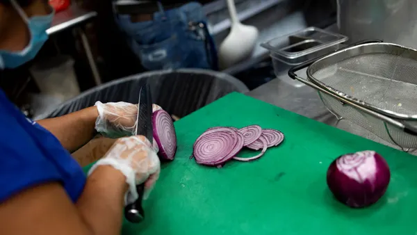A cook cuts onions in the kitchen at Ben's Chili Bowl on August 22, 2022 in Washington, DC.