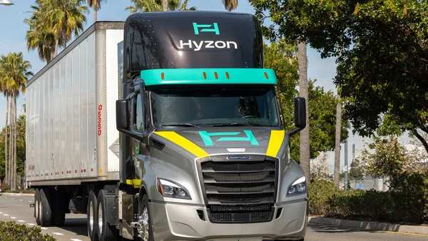 A Hyzon tractor-trailer on a road lined with palm trees.