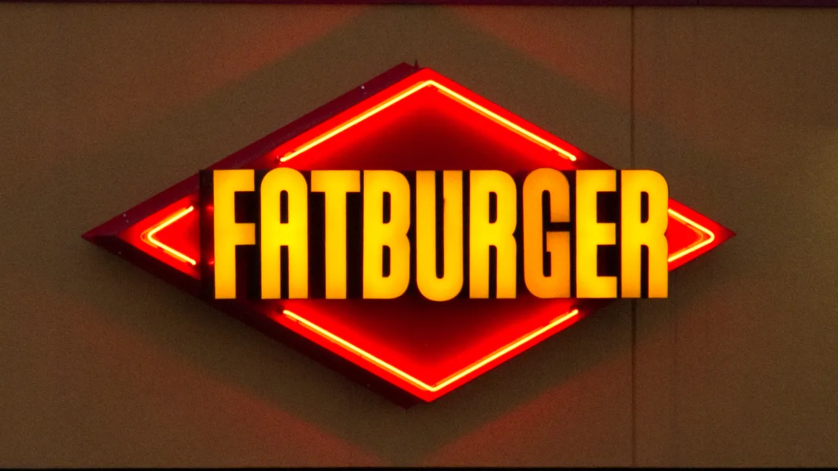 A picture of a diamond red sign that has "Fatburger" in yellow letters.