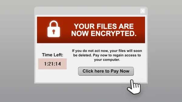 A computer screen is shown with a ransomware attack note visible on the screen.