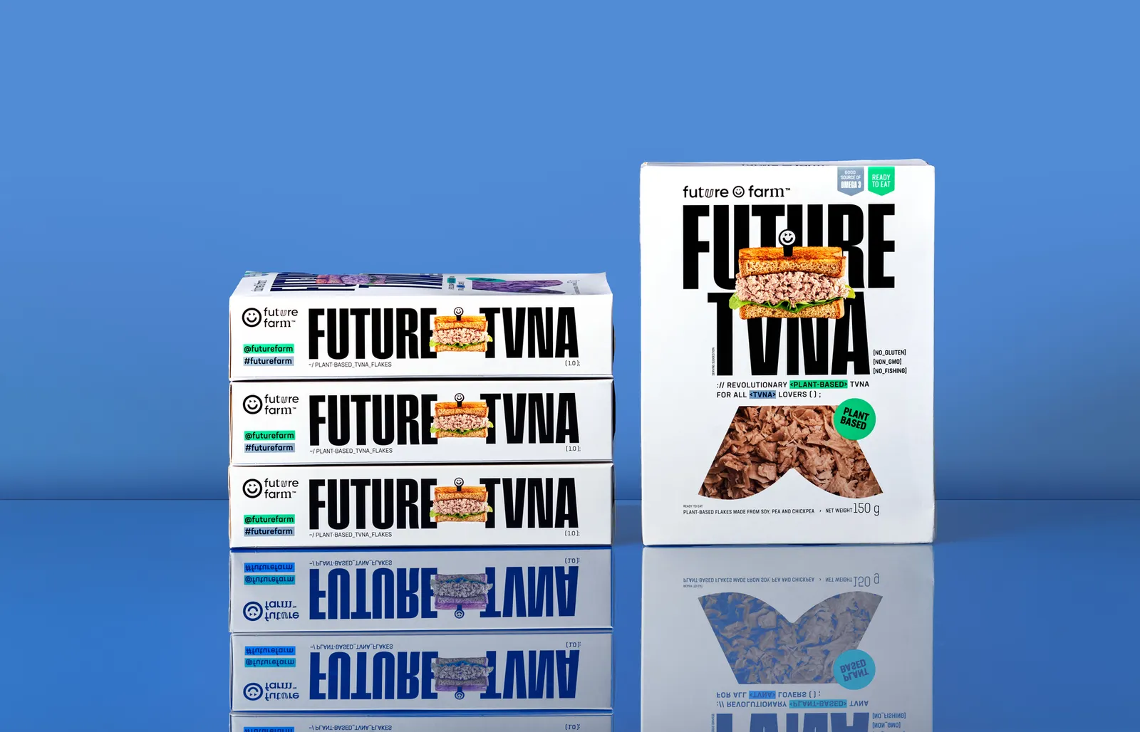 Three boxes of Future Tvna are stacked and sitting on a reflective surface with a blue background. One box of Future Tvna is standing up to its right.