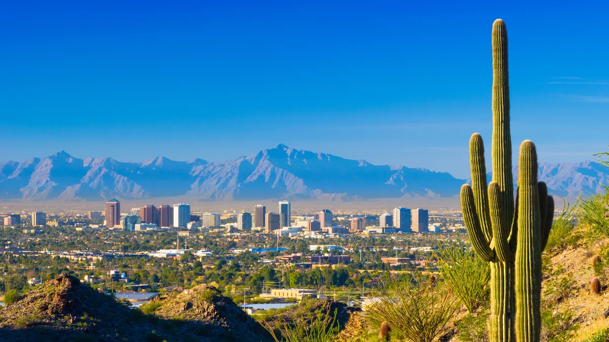 Phoenix midtown skyline with a Saguaro Cactus and other desert scenery in the foreground.