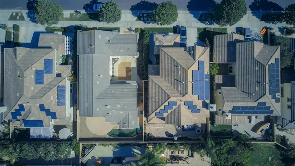 Overview shot of houses with solar panels on their roofs.
